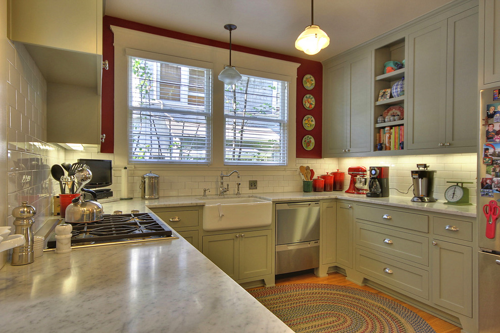 Example of a mid-sized arts and crafts u-shaped medium tone wood floor enclosed kitchen design in San Francisco with a farmhouse sink, shaker cabinets, green cabinets, marble countertops, white backsplash, subway tile backsplash, stainless steel appliances and no island