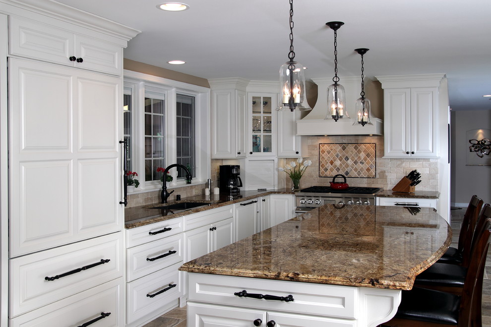 Inredning av ett klassiskt kök, med en undermonterad diskho, luckor med upphöjd panel, vita skåp, granitbänkskiva, beige stänkskydd, stänkskydd i stenkakel och rostfria vitvaror