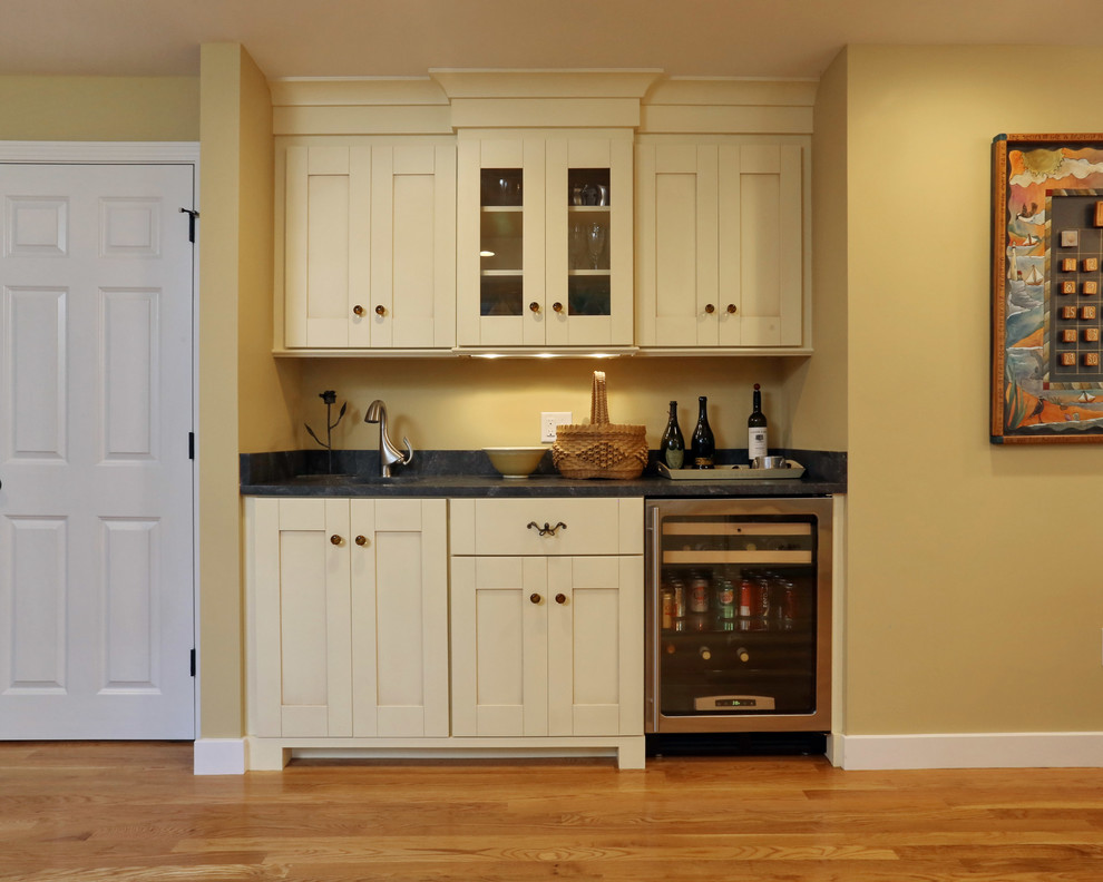 Example of a large classic l-shaped light wood floor enclosed kitchen design in Boston with shaker cabinets, beige cabinets, an island, an undermount sink and stainless steel appliances