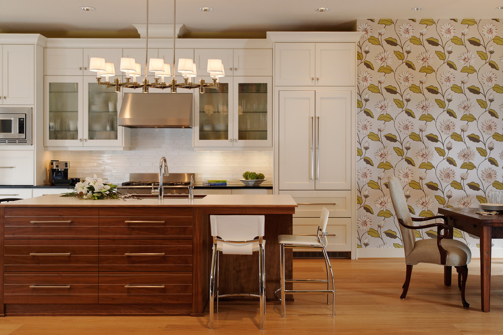 Example of a transitional eat-in kitchen design in Portland with recessed-panel cabinets, beige cabinets, white backsplash and stainless steel appliances