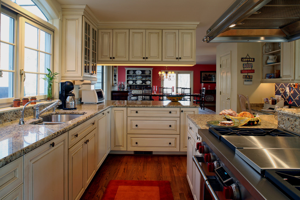 Landhaus Wohnküche mit Unterbauwaschbecken, profilierten Schrankfronten, hellen Holzschränken, Granit-Arbeitsplatte, Elektrogeräten mit Frontblende, braunem Holzboden und zwei Kücheninseln in Baltimore