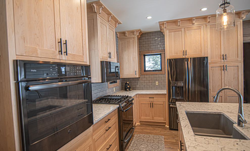 Example of a mid-sized arts and crafts l-shaped vinyl floor open concept kitchen design in Other with an undermount sink, shaker cabinets, light wood cabinets, quartzite countertops, gray backsplash, ceramic backsplash, stainless steel appliances, an island and multicolored countertops