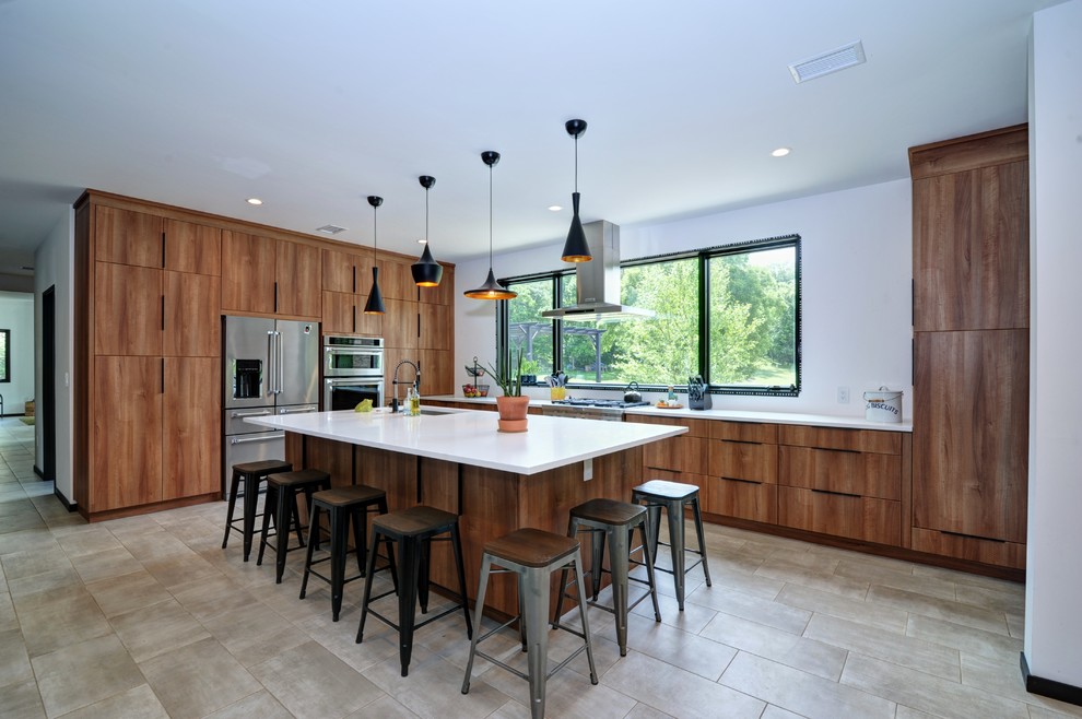 Photo of a traditional l-shaped kitchen in Other with a submerged sink, flat-panel cabinets, medium wood cabinets, engineered stone countertops, stainless steel appliances, ceramic flooring, an island, grey floors and white worktops.