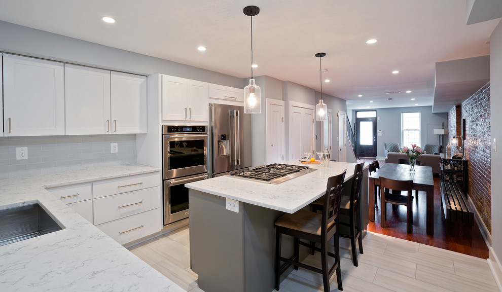 Inspiration for a mid-sized transitional l-shaped white floor and porcelain tile eat-in kitchen remodel in DC Metro with an undermount sink, white cabinets, quartz countertops, subway tile backsplash, stainless steel appliances, an island, white countertops, shaker cabinets and white backsplash