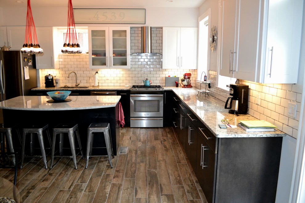 Inspiration for a large industrial l-shaped porcelain tile eat-in kitchen remodel in St Louis with an undermount sink, subway tile backsplash, stainless steel appliances and an island