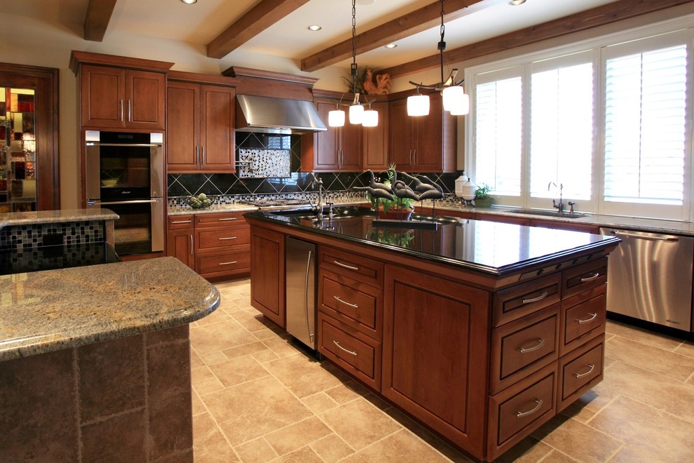 Photo of a large classic kitchen in Wichita with a submerged sink, raised-panel cabinets, medium wood cabinets, granite worktops, black splashback, stainless steel appliances and multiple islands.