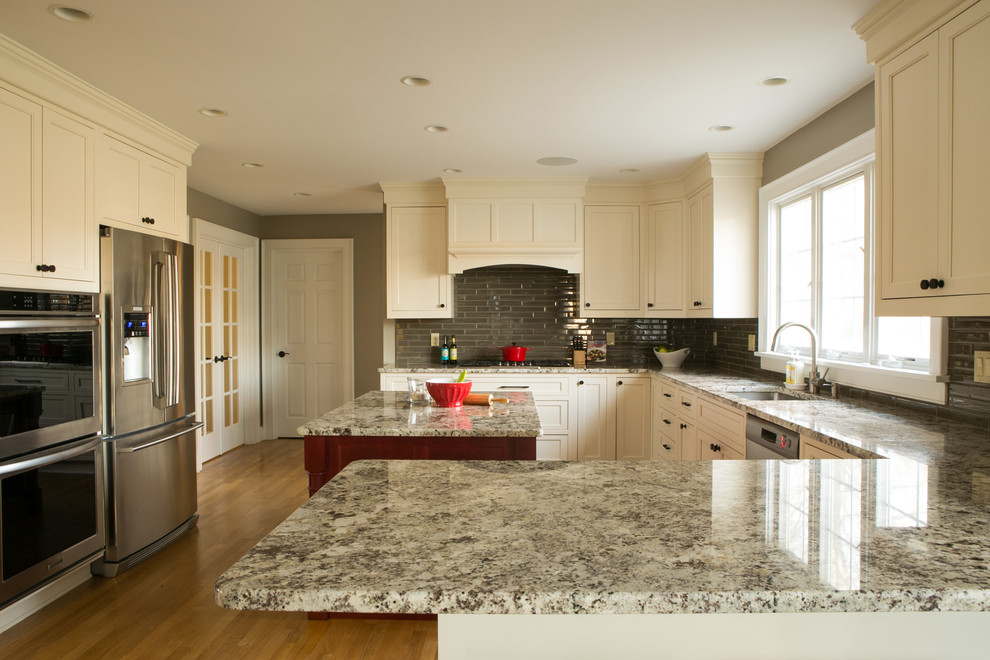 Eat-in kitchen - large transitional u-shaped light wood floor eat-in kitchen idea in Providence with an undermount sink, shaker cabinets, white cabinets, granite countertops, green backsplash, glass tile backsplash, stainless steel appliances and an island