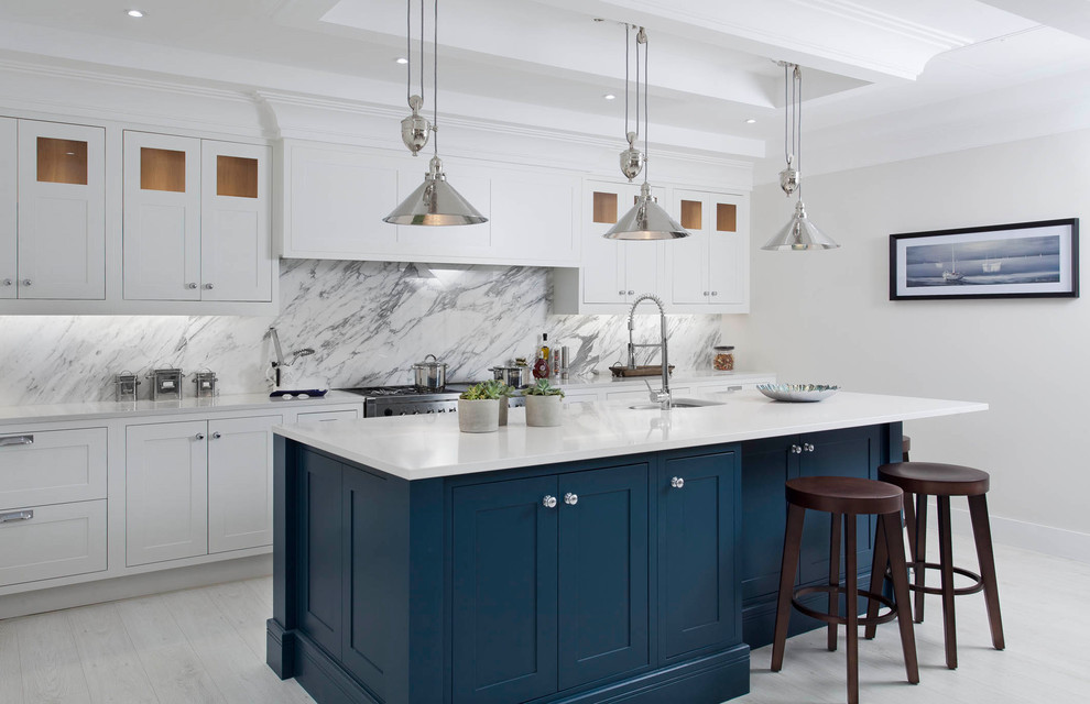 Example of a mid-sized transitional l-shaped light wood floor and white floor open concept kitchen design in Other with an undermount sink, shaker cabinets, gray cabinets, quartzite countertops, gray backsplash, marble backsplash, stainless steel appliances and an island
