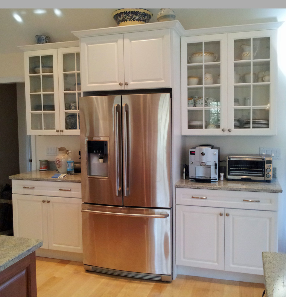 Photo of a large classic u-shaped kitchen/diner in New York with a double-bowl sink, shaker cabinets, white cabinets, granite worktops, stainless steel appliances, bamboo flooring and an island.