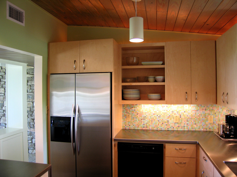 Retro Küche mit Rückwand aus Mosaikfliesen, Edelstahl-Arbeitsplatte, offenen Schränken, hellbraunen Holzschränken, bunter Rückwand und Küchengeräten aus Edelstahl in Austin
