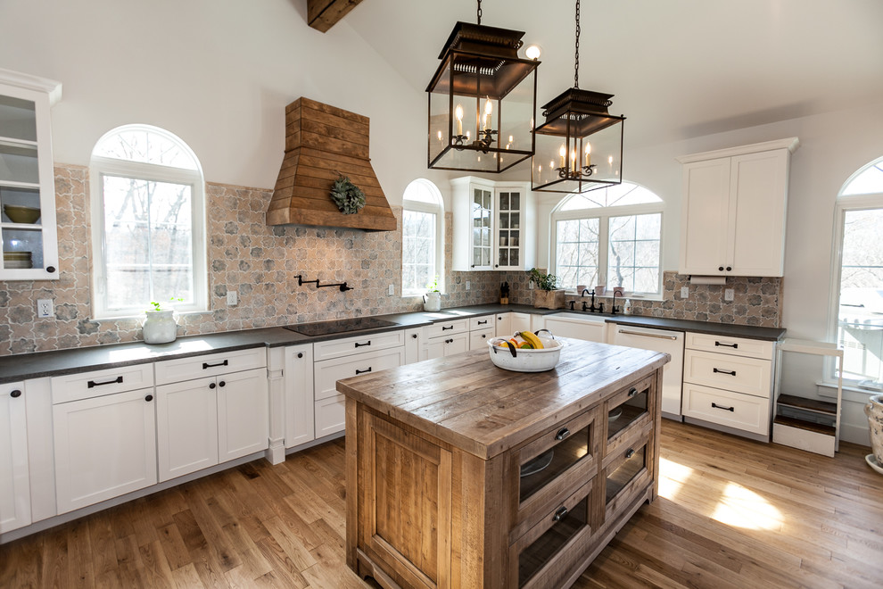 Example of a farmhouse medium tone wood floor kitchen design in St Louis with granite countertops, ceramic backsplash, an island and black countertops
