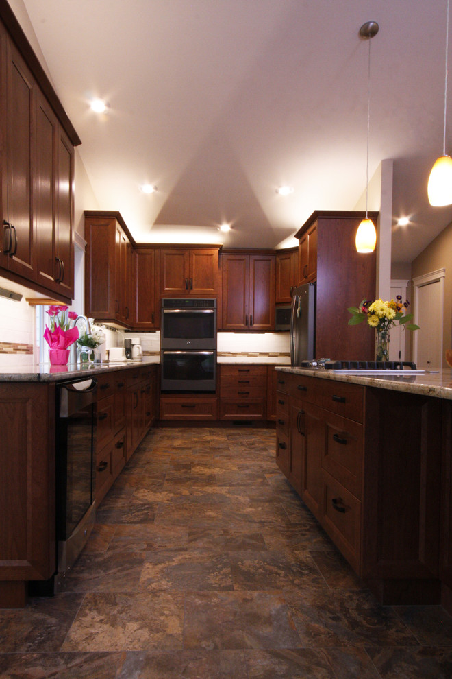 Klassische Küche mit Granit-Arbeitsplatte, weißen Elektrogeräten und Kücheninsel in Seattle