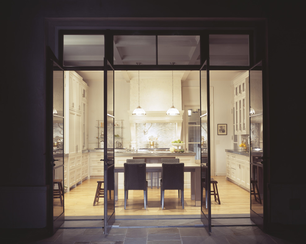 Klassische Wohnküche mit weißen Schränken, Küchenrückwand in Weiß und Rückwand aus Steinfliesen in Los Angeles