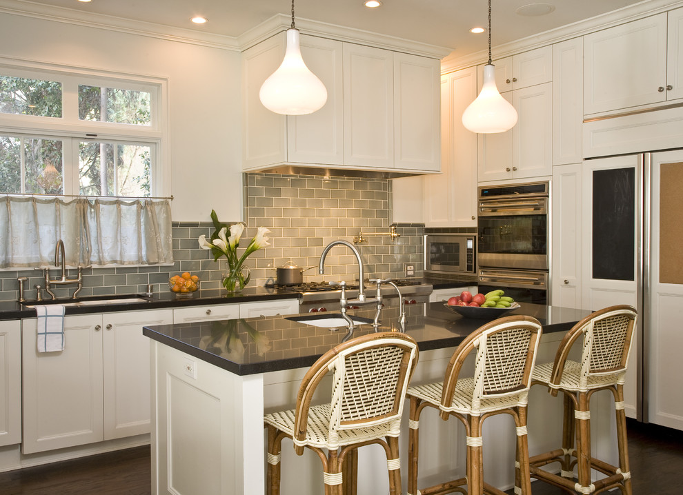 Kitchen - traditional u-shaped kitchen idea in Los Angeles with paneled appliances, an undermount sink, recessed-panel cabinets, white cabinets, quartz countertops, gray backsplash and subway tile backsplash