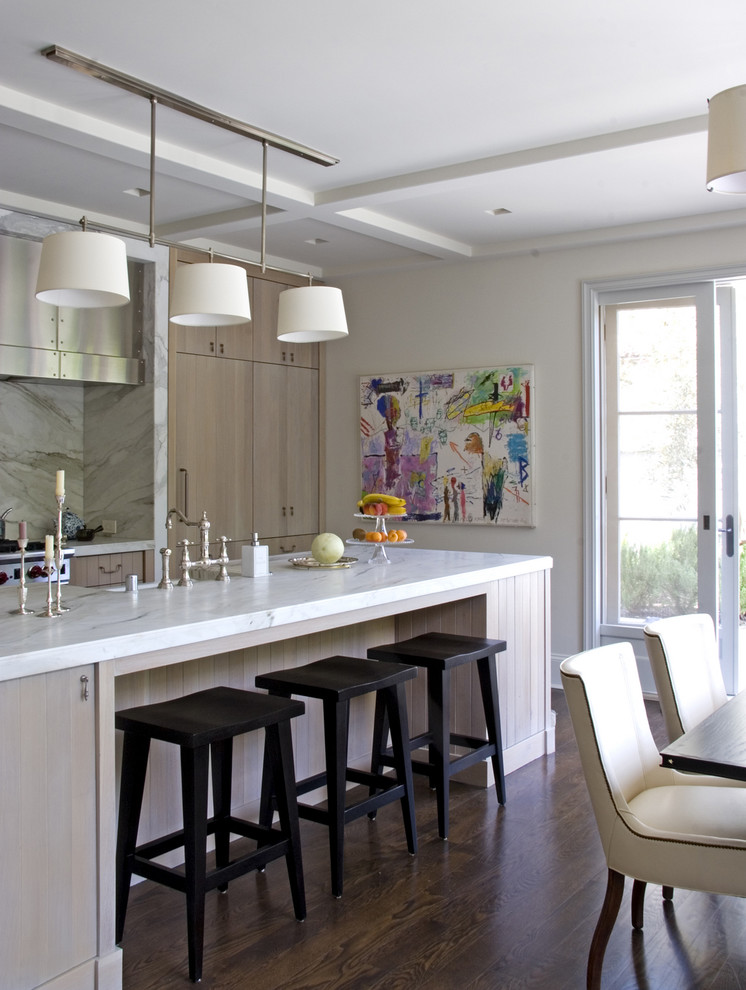 Cette image montre une cuisine américaine parallèle traditionnelle en bois clair avec plan de travail en marbre, un placard à porte plane, une crédence blanche et une crédence en dalle de pierre.