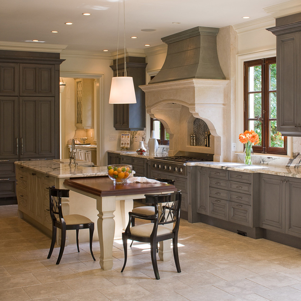 Inspiration for a large timeless u-shaped travertine floor enclosed kitchen remodel in Atlanta with an island, gray cabinets, marble countertops, a farmhouse sink, stainless steel appliances, raised-panel cabinets, white backsplash and stone slab backsplash