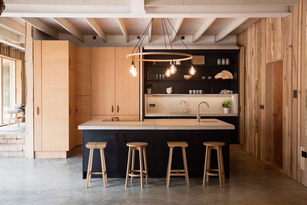 Exempel på ett mellanstort modernt grå linjärt grått kök, med en undermonterad diskho, luckor med upphöjd panel, skåp i ljust trä, bänkskiva i betong, grått stänkskydd, stänkskydd i keramik, rostfria vitvaror, betonggolv, en köksö och grått golv