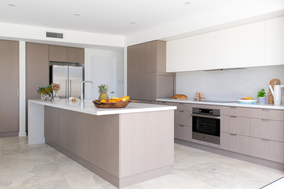 Small modern galley kitchen/diner in Sydney with a submerged sink, white cabinets, engineered stone countertops, white splashback, stone slab splashback, stainless steel appliances, ceramic flooring and an island.