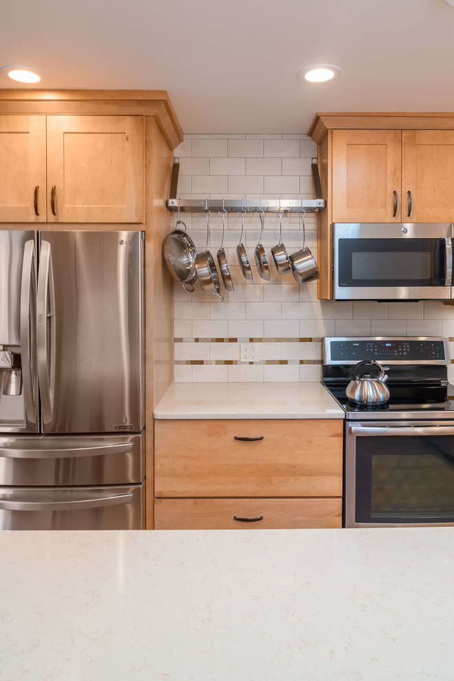 Diseño de cocina tradicional de tamaño medio con fregadero bajoencimera, armarios estilo shaker, puertas de armario de madera oscura, encimera de cuarzo compacto, salpicadero blanco, salpicadero de azulejos de cerámica, electrodomésticos de acero inoxidable, suelo de baldosas de porcelana, una isla, suelo multicolor y encimeras blancas