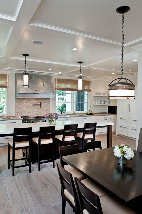 Traditional kitchen in Indianapolis with a submerged sink, recessed-panel cabinets, white cabinets, beige splashback, stainless steel appliances, light hardwood flooring, an island and brown floors.