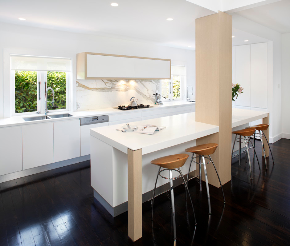Einzeilige Moderne Wohnküche mit Einbauwaschbecken, flächenbündigen Schrankfronten, weißen Schränken, Mineralwerkstoff-Arbeitsplatte, Rückwand aus Stein und Küchengeräten aus Edelstahl in Sydney