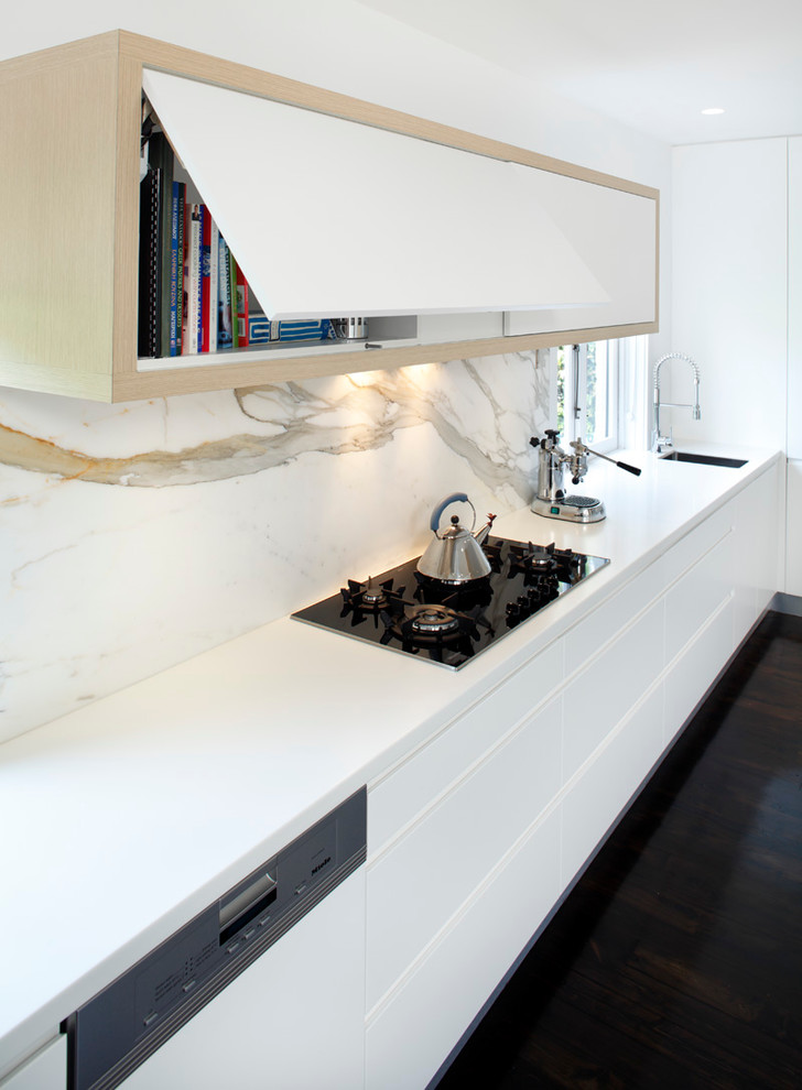 Inspiration for a modern single-wall eat-in kitchen remodel in Sydney with a drop-in sink, flat-panel cabinets, white cabinets, solid surface countertops, stainless steel appliances, white backsplash and marble backsplash