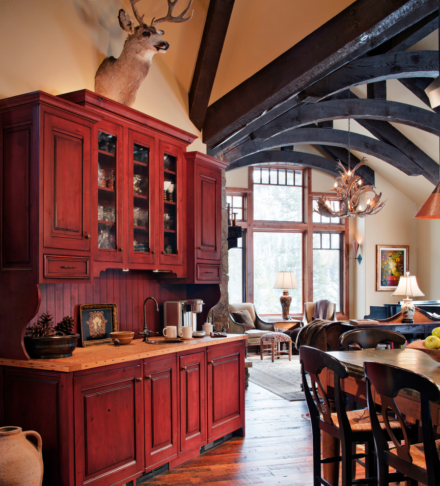 Foto på ett mellanstort vintage kök, med en rustik diskho, luckor med infälld panel, beige skåp, rostfria vitvaror, mellanmörkt trägolv, en köksö och brunt golv
