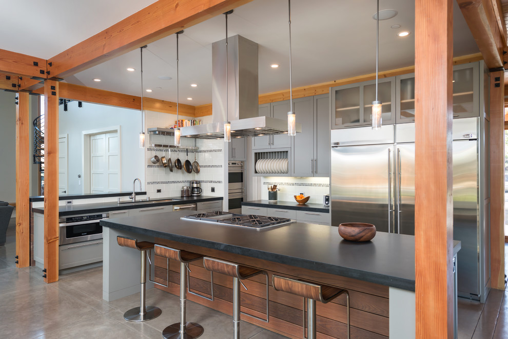 Open concept kitchen - large traditional l-shaped concrete floor open concept kitchen idea in San Francisco with an undermount sink, shaker cabinets, gray cabinets, soapstone countertops, multicolored backsplash, ceramic backsplash, stainless steel appliances and an island