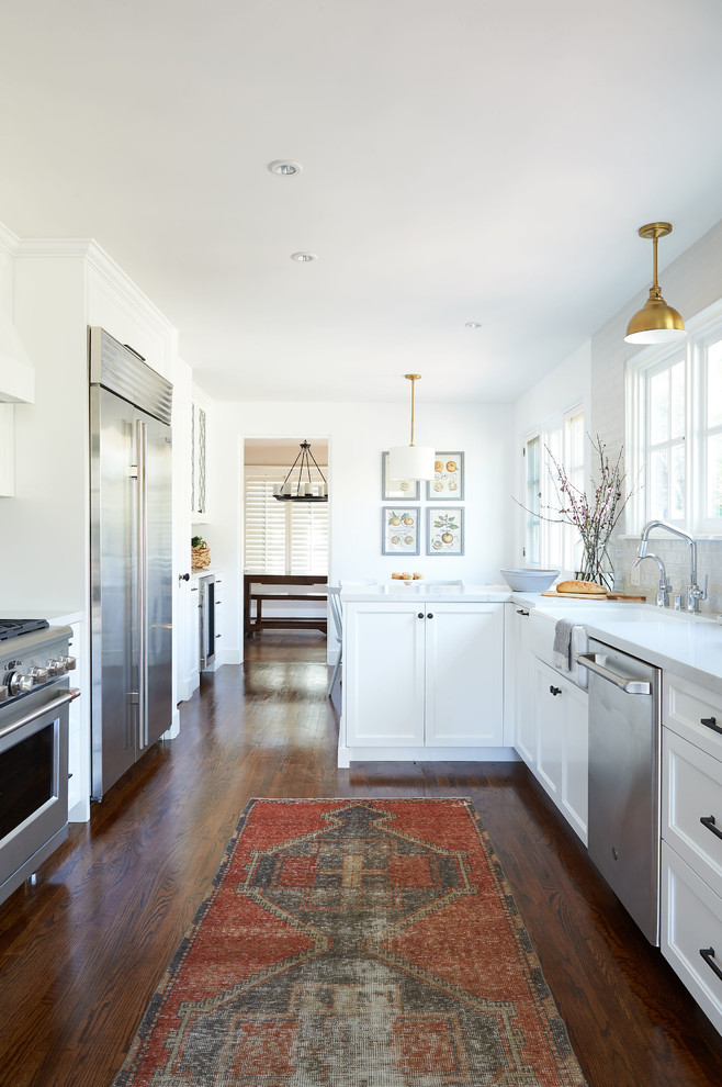 Mid-sized beach style galley medium tone wood floor and brown floor eat-in kitchen photo in San Diego with an undermount sink, shaker cabinets, white cabinets, quartz countertops, gray backsplash, ceramic backsplash, stainless steel appliances, an island and white countertops