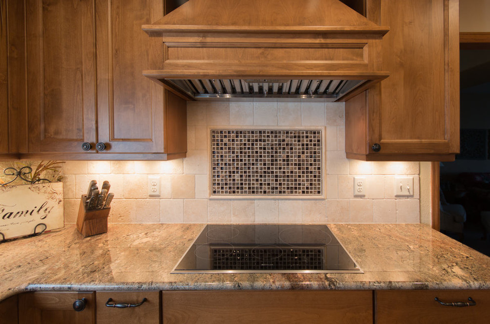 Inspiration pour une cuisine américaine traditionnelle en U de taille moyenne avec un évier 1 bac, un placard à porte shaker, des portes de placard marrons, un plan de travail en granite, une crédence en carrelage de pierre, un électroménager en acier inoxydable, un sol en bois brun, îlot et un sol marron.