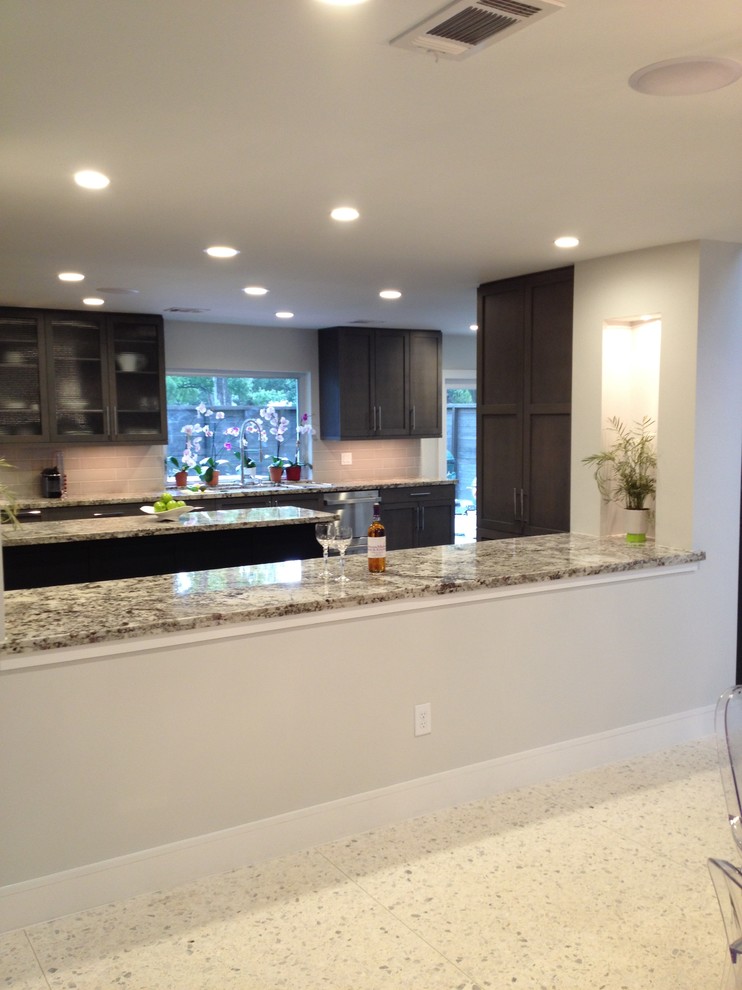 Photo of a large contemporary open plan kitchen in Houston with a submerged sink, shaker cabinets, grey cabinets, granite worktops, grey splashback, ceramic splashback, stainless steel appliances, dark hardwood flooring and an island.
