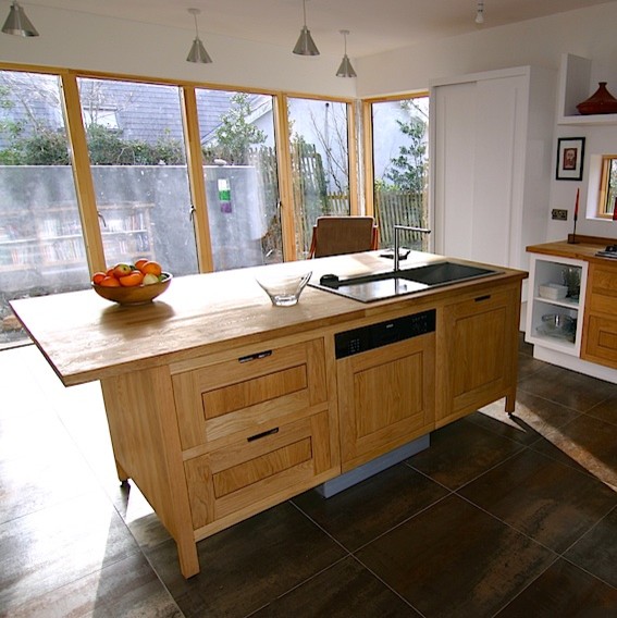 Moderne Wohnküche mit Einbauwaschbecken, Schrankfronten im Shaker-Stil, hellbraunen Holzschränken, Arbeitsplatte aus Holz und Küchengeräten aus Edelstahl in Sonstige