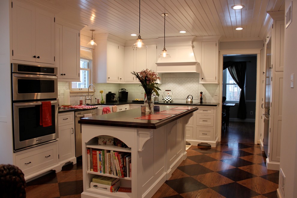 Modern inredning av ett avskilt, mellanstort l-kök, med en rustik diskho, vita skåp, vitt stänkskydd, rostfria vitvaror, en köksö, skåp i shakerstil, träbänkskiva, stänkskydd i tunnelbanekakel och linoleumgolv