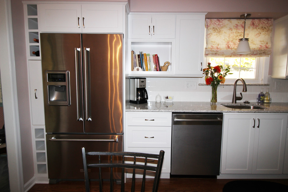 Diseño de cocina tradicional renovada de tamaño medio con puertas de armario blancas, encimera de cuarzo compacto, salpicadero blanco, salpicadero de azulejos tipo metro y electrodomésticos de acero inoxidable