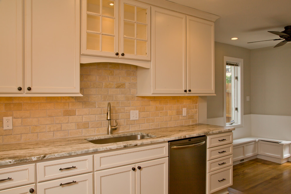 Example of a large transitional l-shaped light wood floor eat-in kitchen design in Wilmington with an undermount sink, raised-panel cabinets, light wood cabinets, granite countertops, beige backsplash, stone tile backsplash, stainless steel appliances and no island