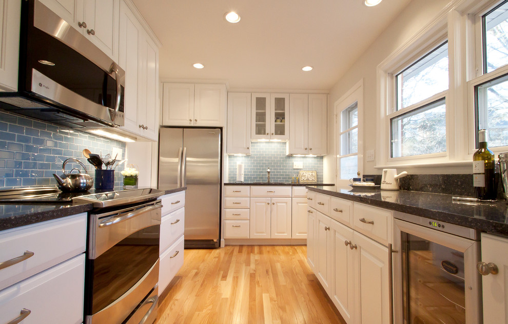 Photo of a contemporary kitchen in DC Metro with raised-panel cabinets, white cabinets and blue splashback.