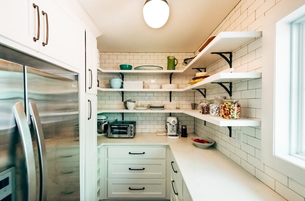 Inspiration for a mid-sized cottage galley medium tone wood floor and brown floor enclosed kitchen remodel in Atlanta with a farmhouse sink, shaker cabinets, white cabinets, marble countertops, white backsplash, wood backsplash, stainless steel appliances and an island