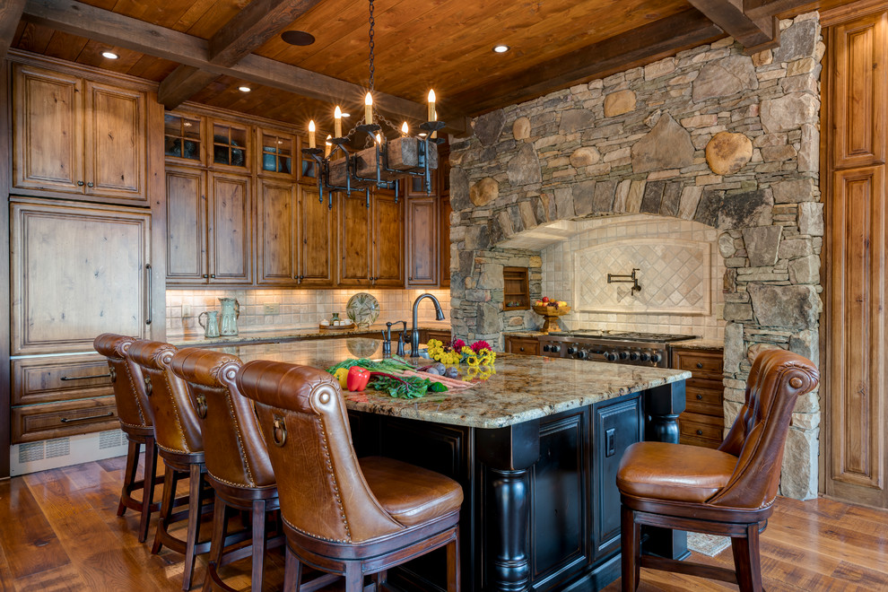 Bild på ett vintage kök med öppen planlösning, med granitbänkskiva, rostfria vitvaror, ljust trägolv och en köksö