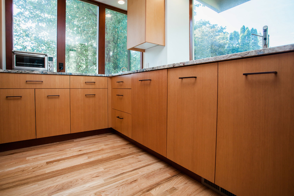 Foto på ett mellanstort funkis flerfärgad kök, med släta luckor, skåp i ljust trä, integrerade vitvaror, en undermonterad diskho, flerfärgad stänkskydd, mellanmörkt trägolv och brunt golv