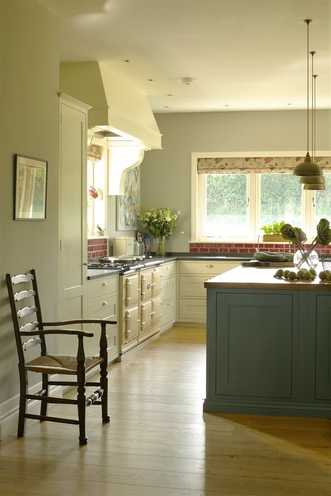 Eat-in kitchen - huge country medium tone wood floor eat-in kitchen idea in Wiltshire with a drop-in sink, shaker cabinets, blue cabinets, granite countertops, red backsplash, subway tile backsplash, colored appliances and an island