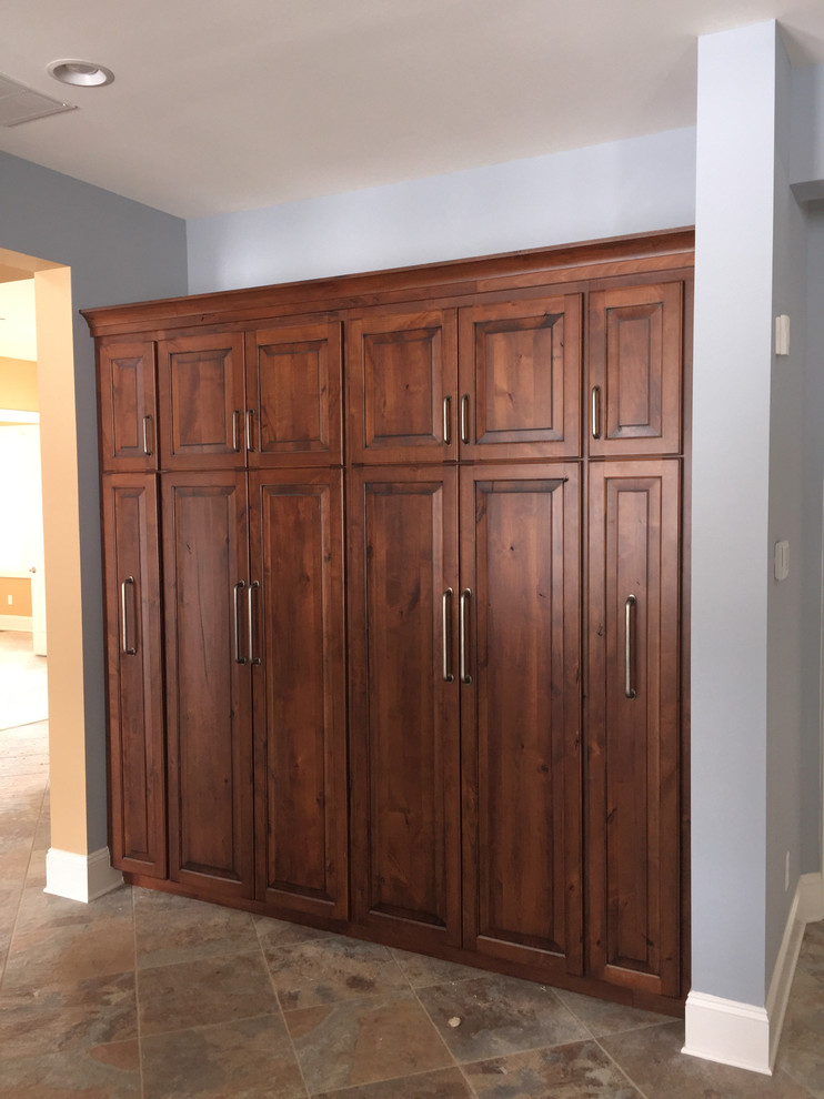 Example of a large classic single-wall kitchen pantry design in Baltimore with raised-panel cabinets, dark wood cabinets and an island
