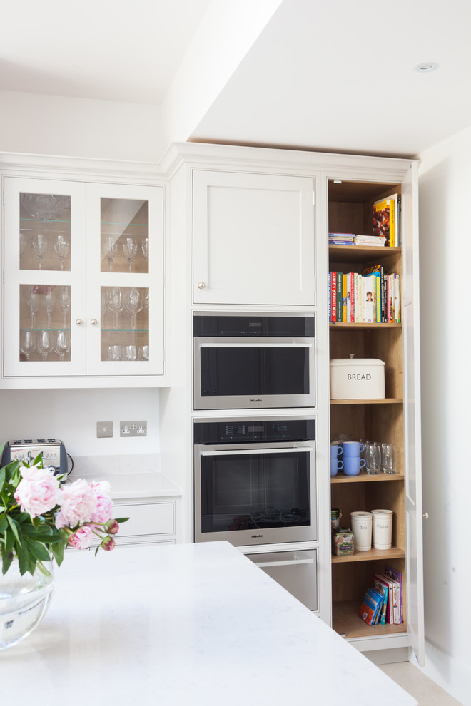 Große, Einzeilige Klassische Wohnküche mit grauen Schränken, Quarzit-Arbeitsplatte, Kücheninsel und Küchenrückwand in Weiß in London