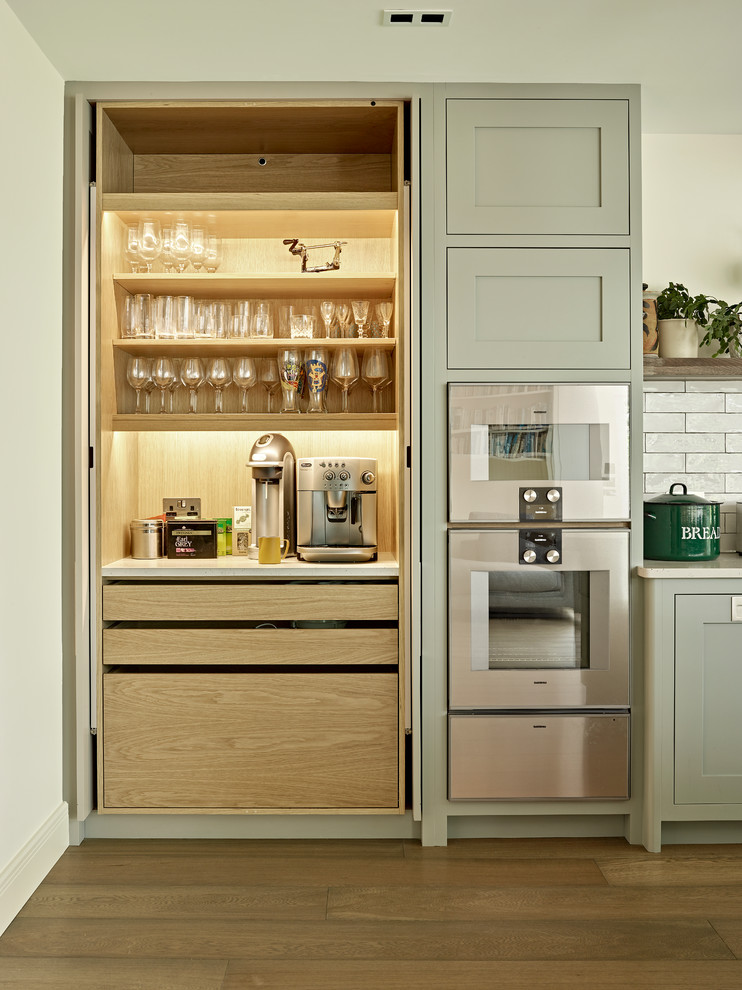 Kitchen - large transitional light wood floor kitchen idea in London with quartzite countertops, white backsplash, subway tile backsplash, stainless steel appliances and white countertops