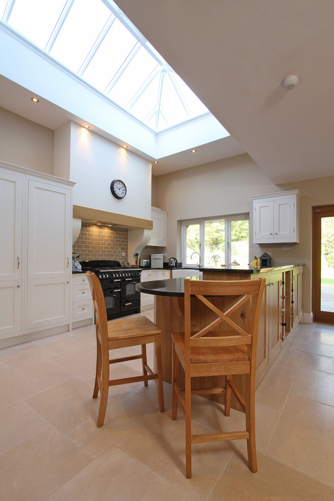 Photo of a contemporary kitchen in Hampshire with shaker cabinets and black appliances.