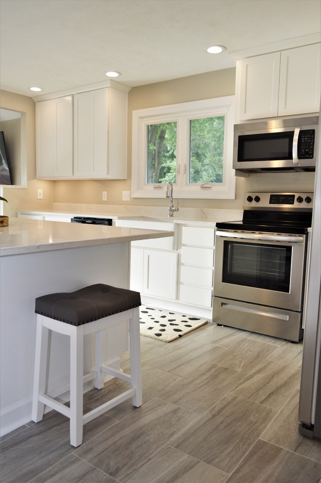 Immagine di una cucina minimal di medie dimensioni con lavello da incasso, ante in stile shaker, ante bianche, top in quarzite, elettrodomestici in acciaio inossidabile, pavimento marrone e top bianco