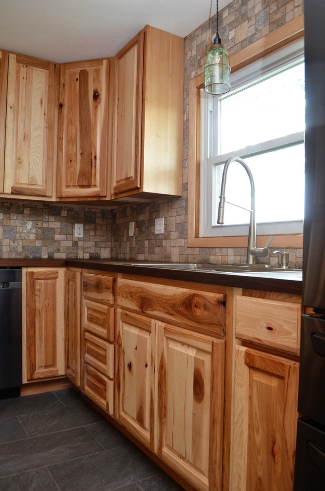 Idéer för ett avskilt, mellanstort rustikt brun l-kök, med en nedsänkt diskho, luckor med upphöjd panel, skåp i ljust trä, träbänkskiva, brunt stänkskydd, stänkskydd i keramik, rostfria vitvaror, cementgolv och grått golv
