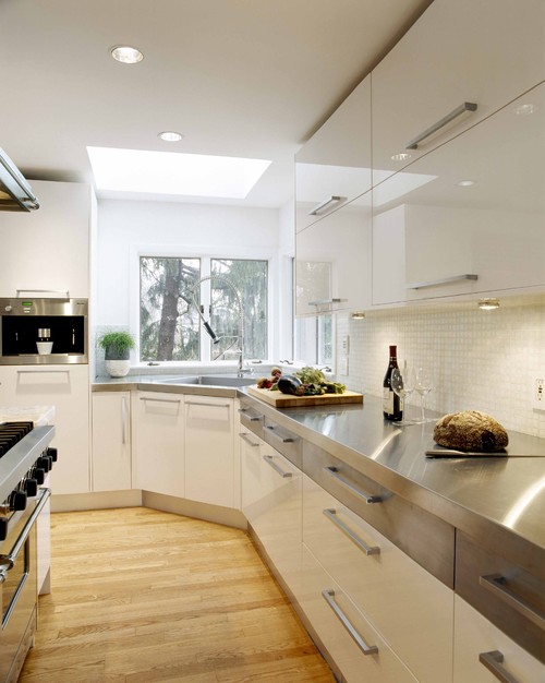 Industrial kitchen with high-gloss black acrylic cabinets, quartz countertop, and stainless backsplash