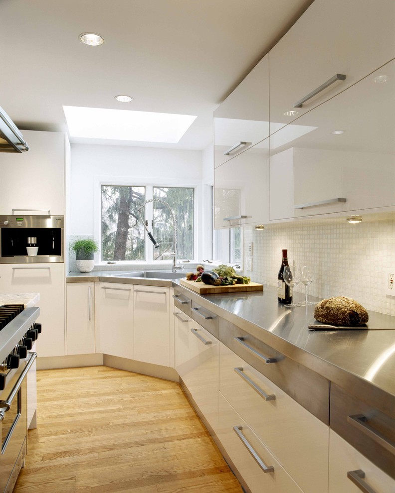Example of a trendy kitchen design in Boston with stainless steel appliances, concrete countertops, an integrated sink, flat-panel cabinets, white cabinets, white backsplash and mosaic tile backsplash