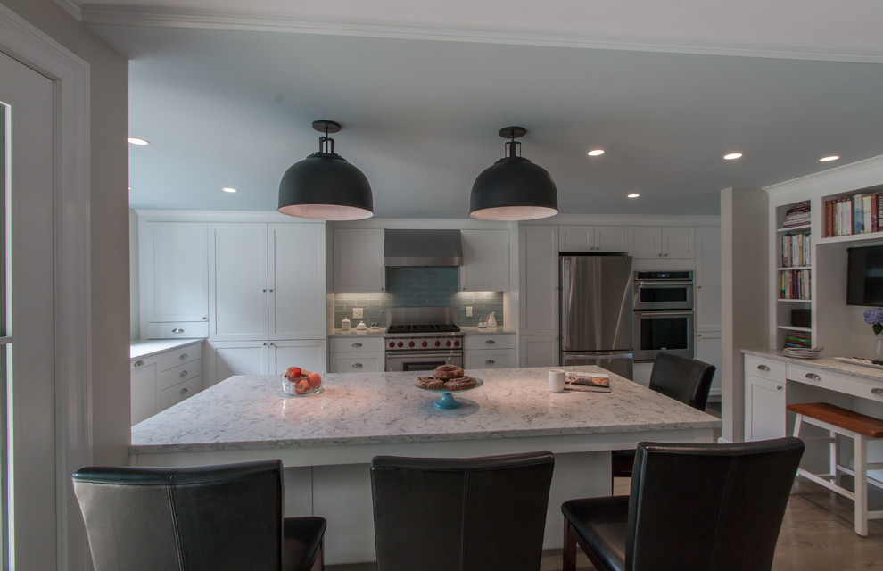 Kitchen - traditional u-shaped medium tone wood floor kitchen idea in Boston with a farmhouse sink, recessed-panel cabinets, white cabinets, quartz countertops, blue backsplash, glass tile backsplash, stainless steel appliances and an island