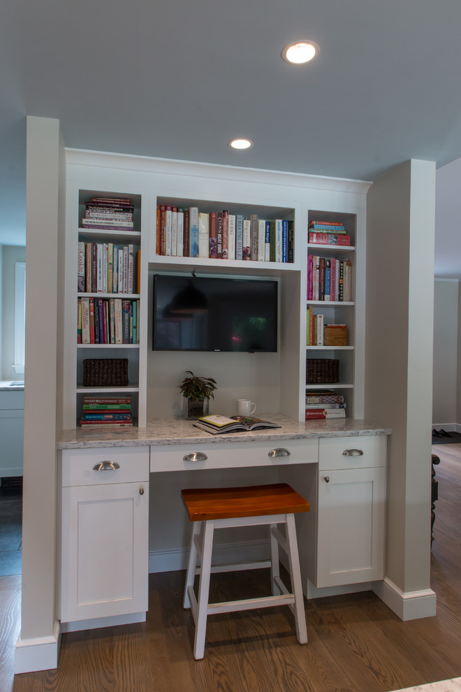 Example of a classic u-shaped medium tone wood floor kitchen design in Boston with a farmhouse sink, recessed-panel cabinets, white cabinets, quartz countertops, blue backsplash, glass tile backsplash, stainless steel appliances and an island
